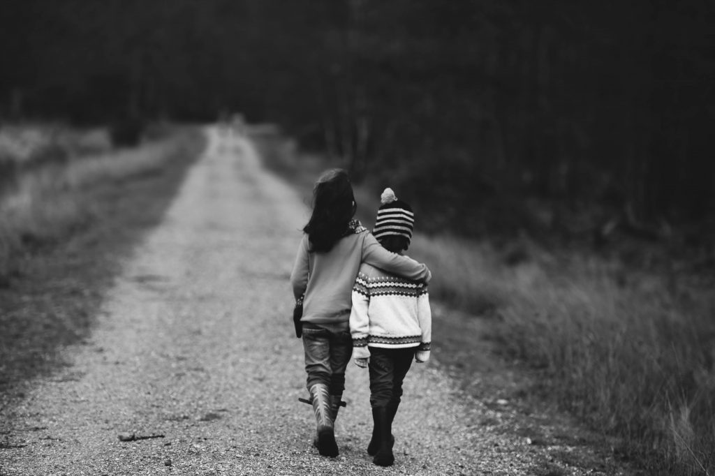 children walking on dirt road (b&w)