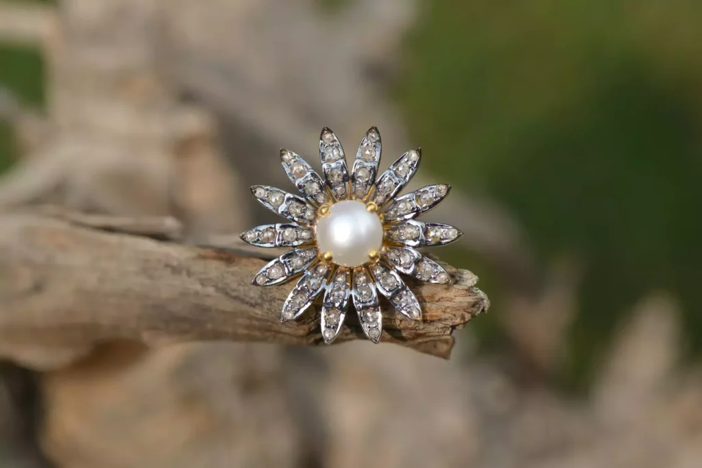 a ring with a pearl and diamonds in the shape of a flower - a symbol of an uncomfortable life