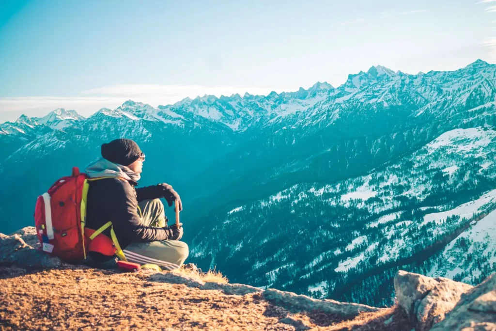 A backpacker looking out over the mountains - Backpacking around the world won't fix you