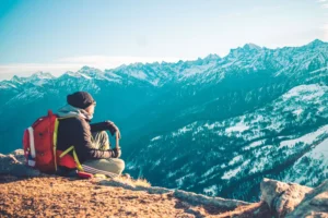 A backpacker looking out over the mountains - Backpacking around the world won't fix you