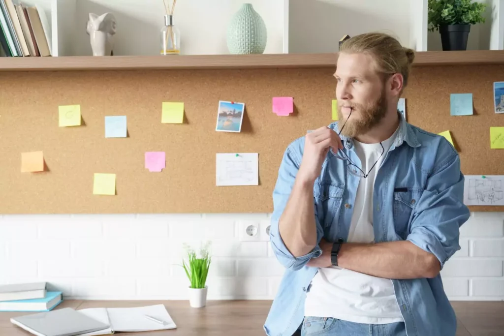 a man with a beard standing in front of a bulletin board - finding true fulfillment