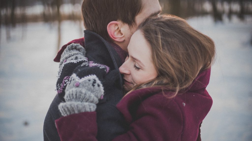 man and woman hugging winter