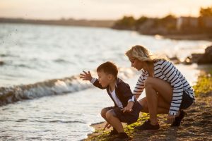 woman and child by beach at sunset