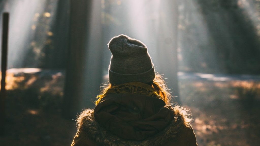 woman in forest with sun rays