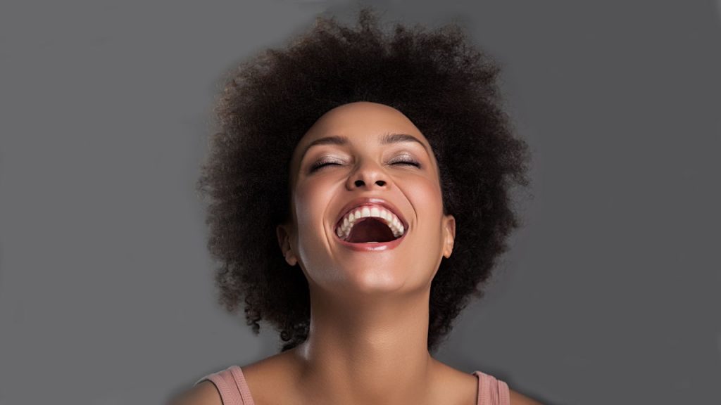 African American woman with short, naturally curly hair laughing