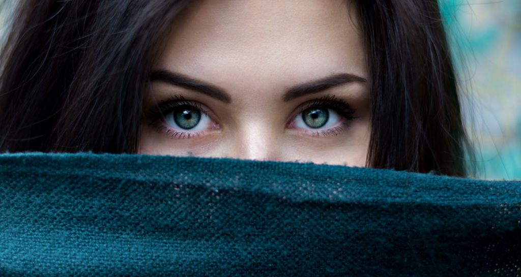 pretty young woman hiding behind fabric