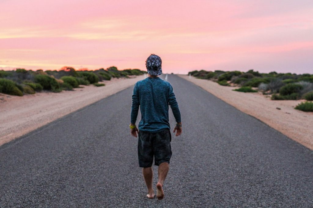 young man walking down a street alone