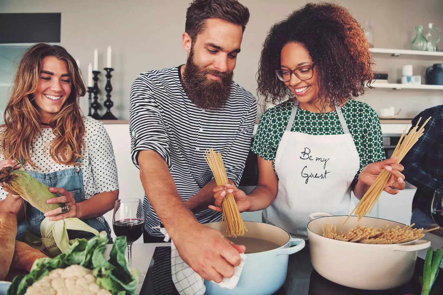 a married couple making dinner with their single friend