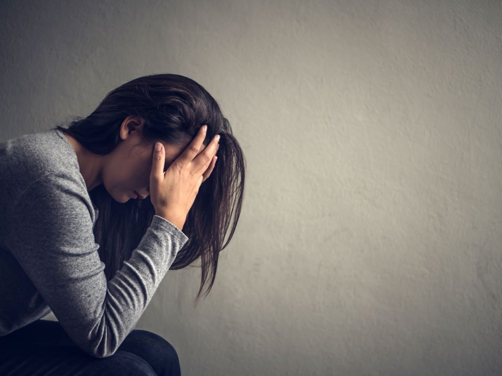 woman holding her head in her hands