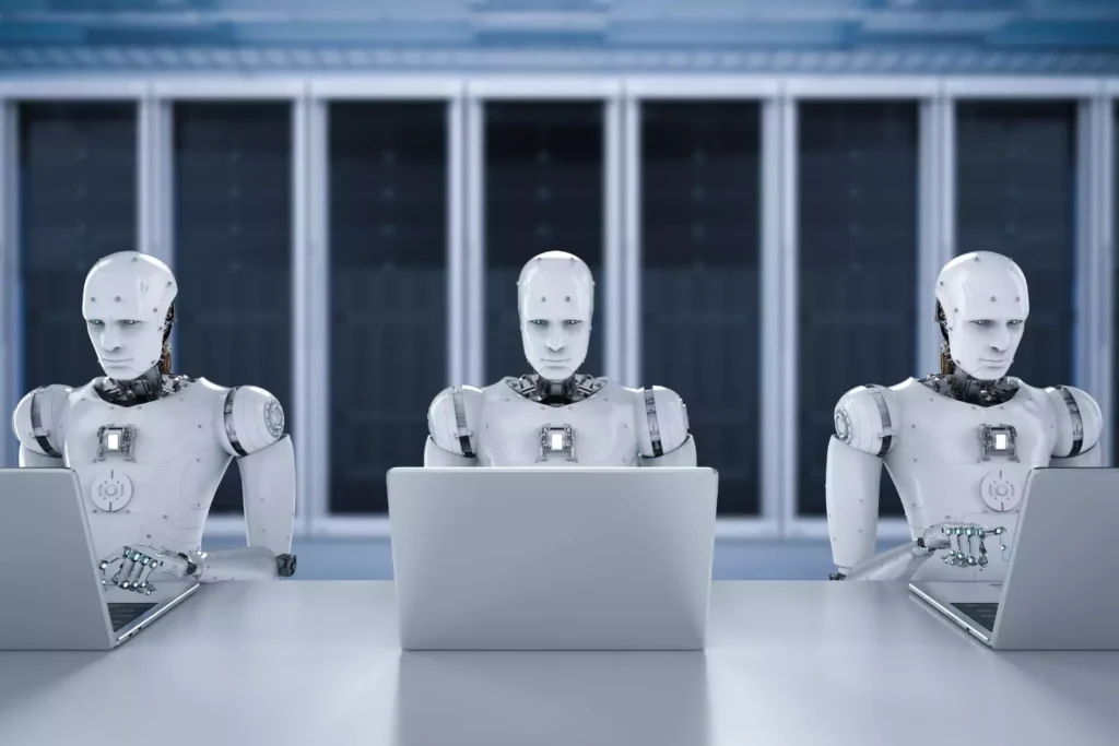3 robots working on computers
