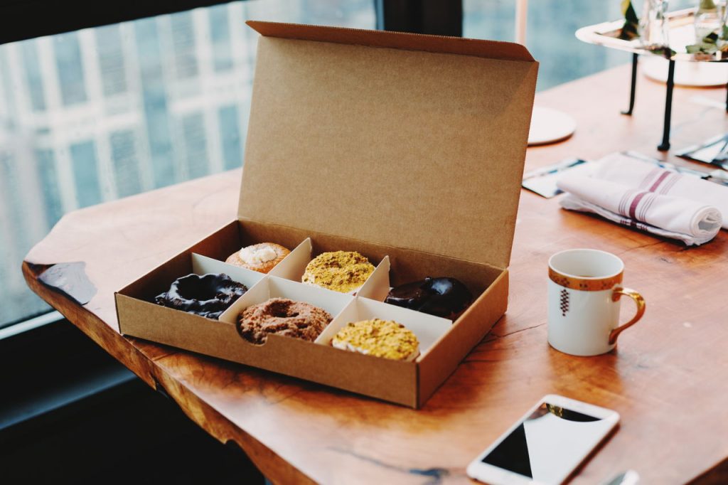 open box of donuts on a desk
