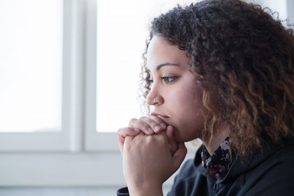 woman thinking, hands folded