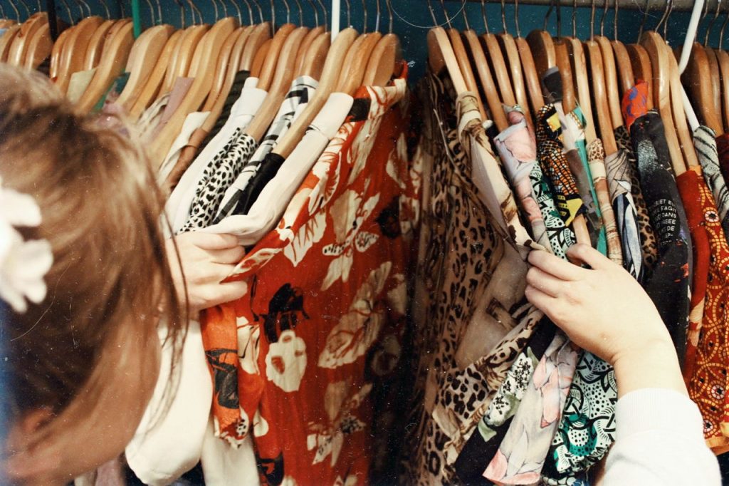 person looking through clothes rack