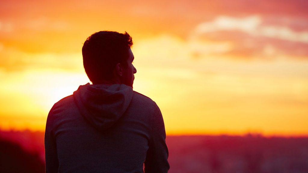 man looking at sunset