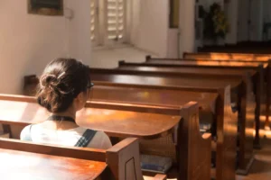 a woman sitting in a church pew, she had the courage to stay