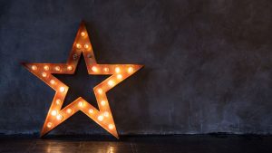 lit up star leaning against a wall