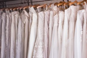 wedding gowns hanging in a row