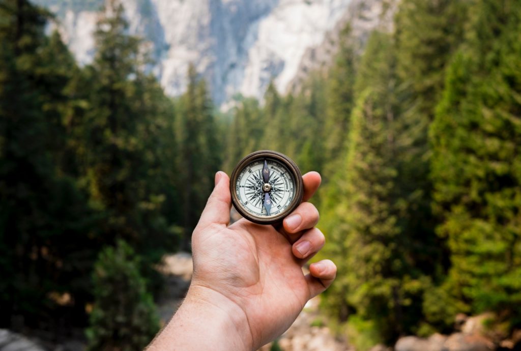 person holding compass outside