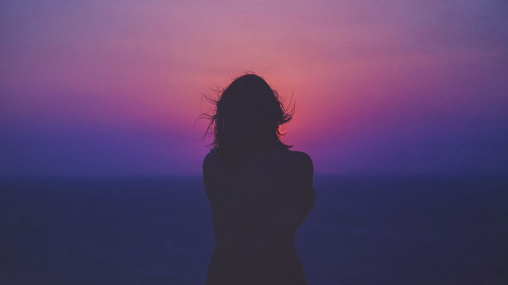 Woman in front of purple sunset