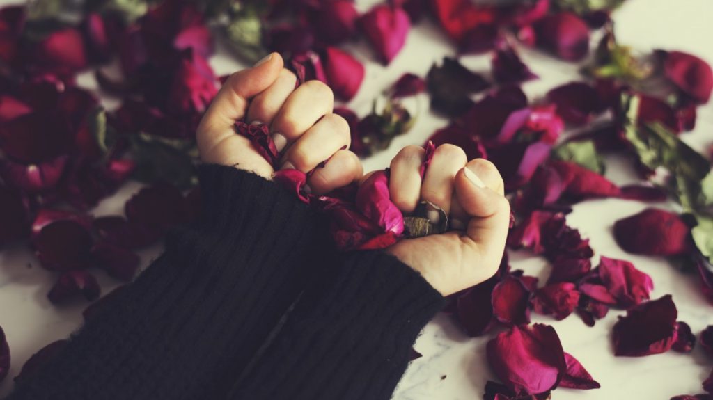 Woman clutching rose petals