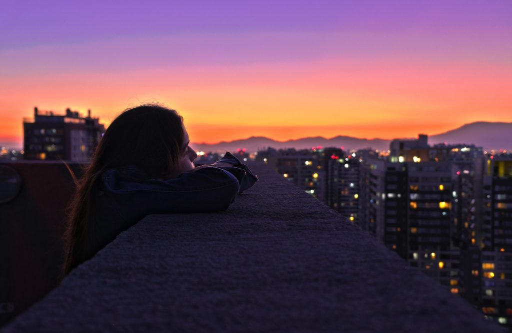 woman on rooftop looking at sunset