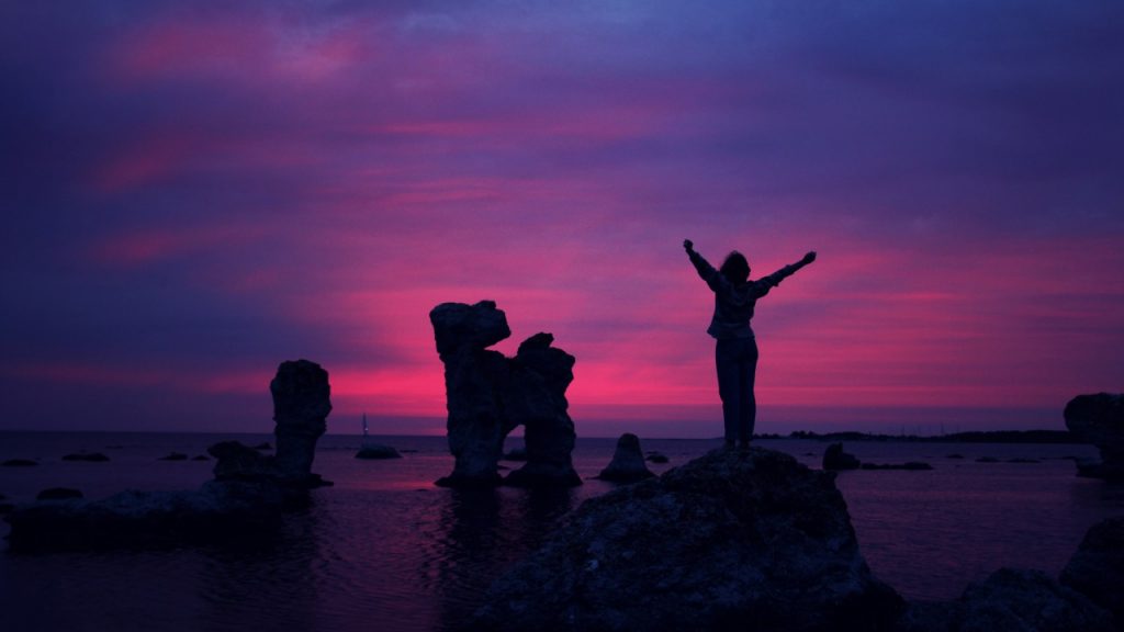 silhouette of woman in front of pink and blue sky