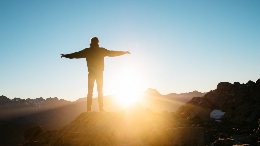 man standing in front of sunset