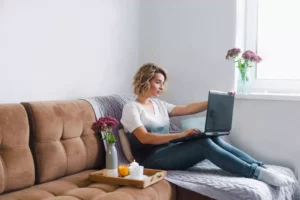woman sitting on her couch working a freelance remote job