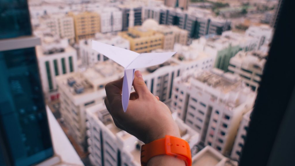 Paper airplane over city