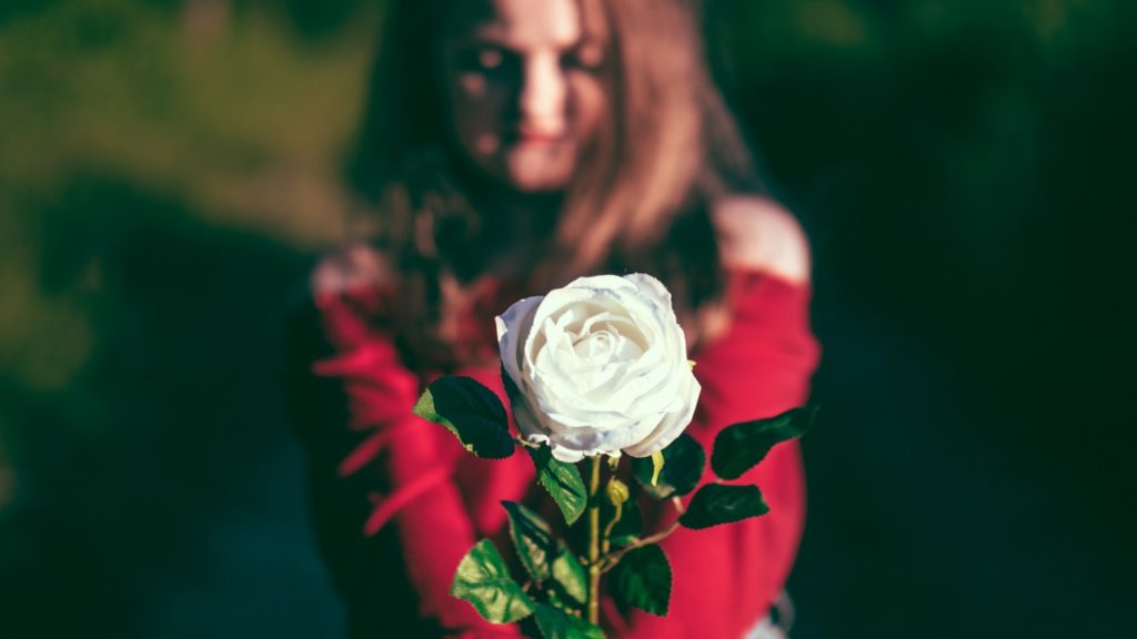 woman holding white rose