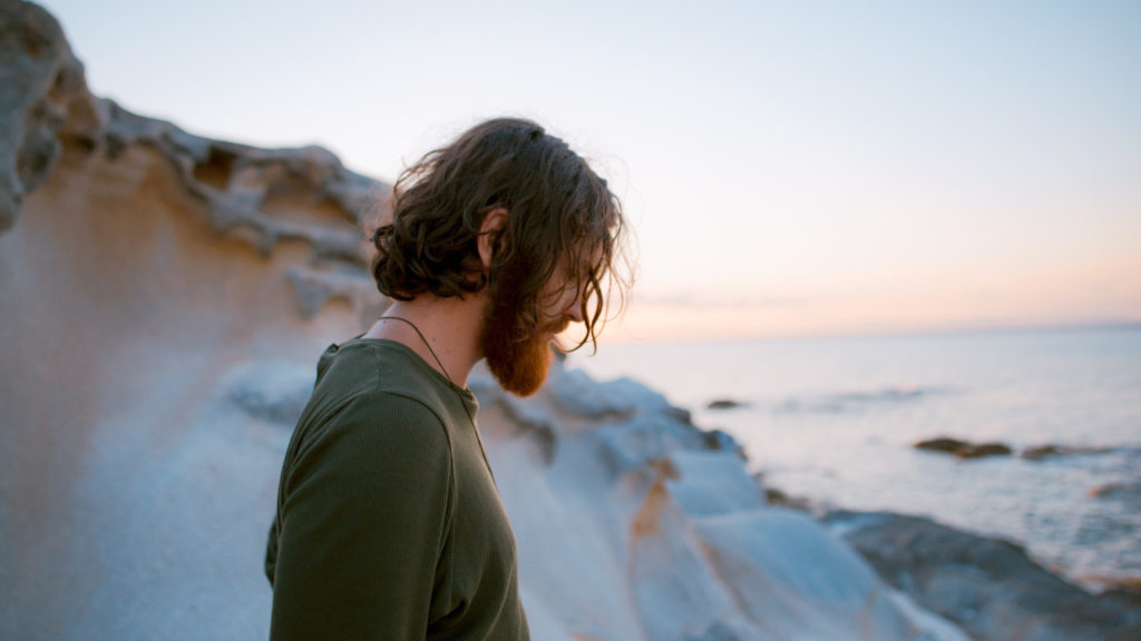 Man looking down at beach