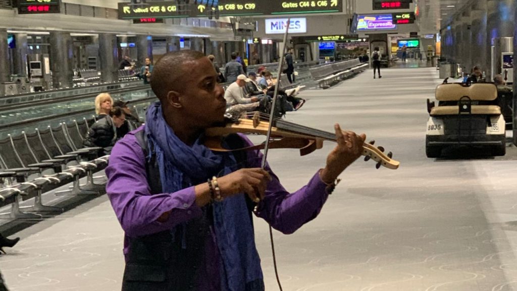 man playing violin in airport