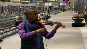 man playing violin in airport