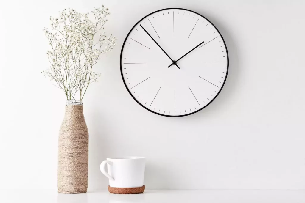 Vase with flowers, mug and clock. Minimalism.