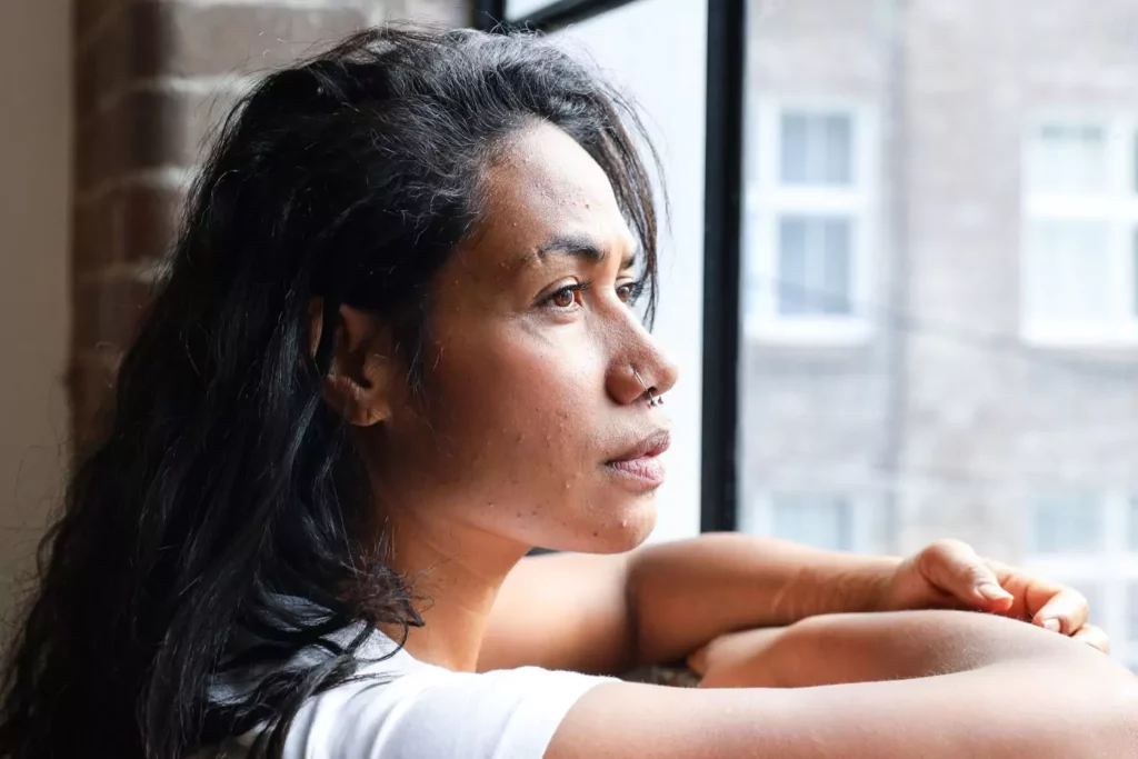 woman looking out a window thinking about her past abortions
