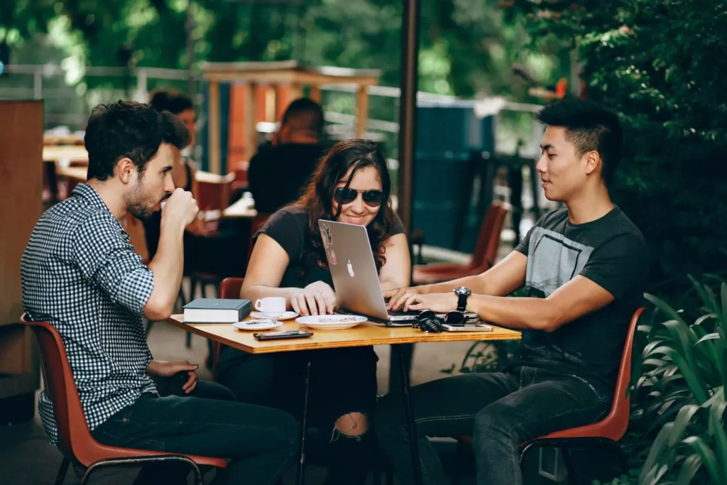 3 friends sitting at a cafe table, adulthood statistics have changed in the last decade