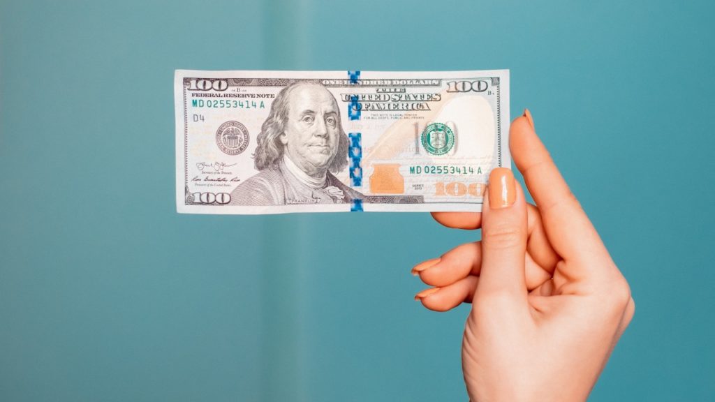 woman holding one hundren dollar bill