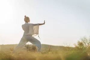 woman doing martial arts in a grassy field. A disciplined life.