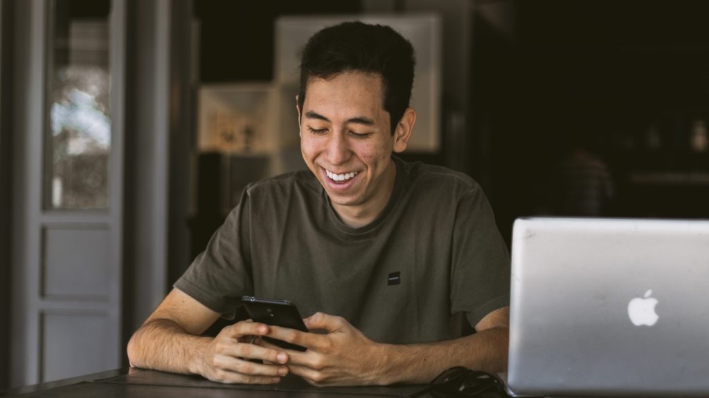 man smiling texting