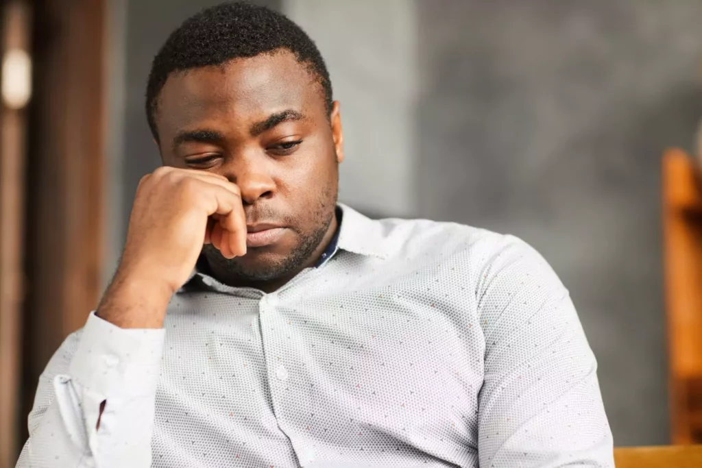 man resting his head on his fist, looking sad, feeling like he is falling apart