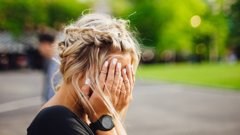 woman with hands over face