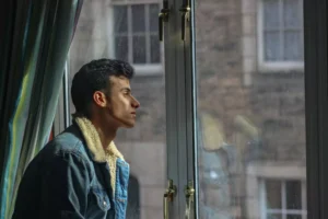 a man looking for the needy outside his window