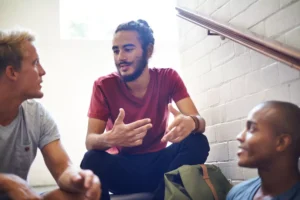 a man takes initiative and begins a conversation with a group of guys