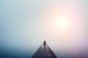 a suffering person walking alone in the fog