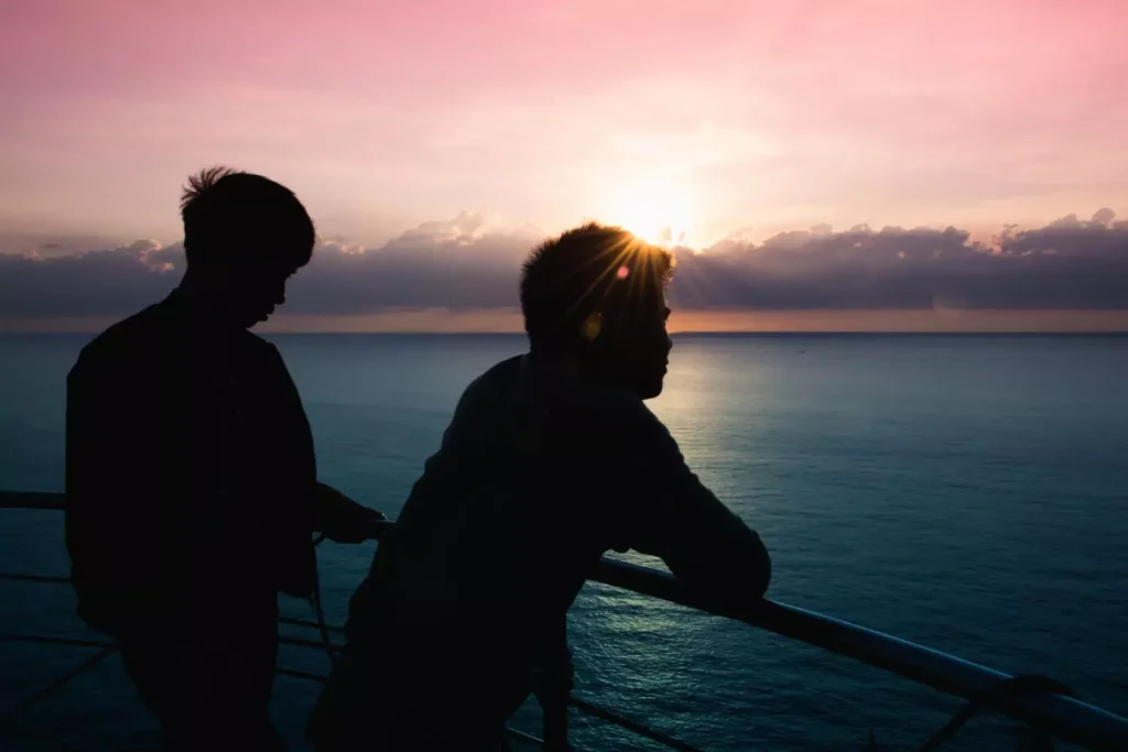two guys looking out over water at sunset. What to say to a friend when they admit they are same-sex attracted