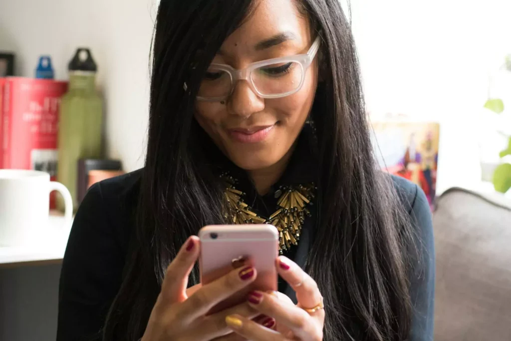 a woman looking at her phone. She's on an online dating app