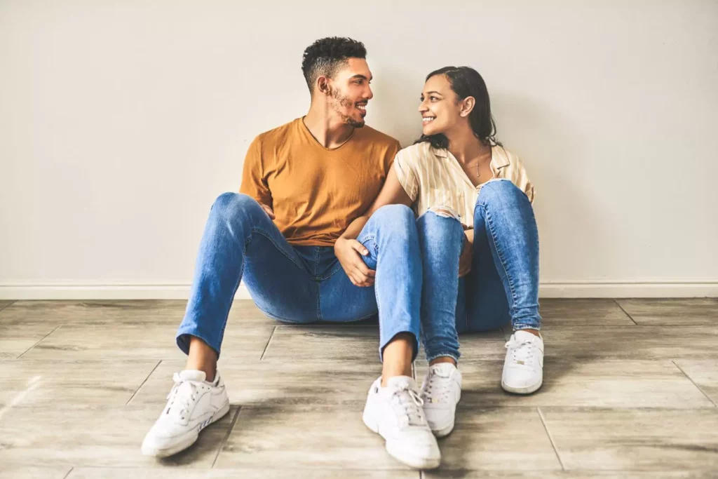 Boyfriend and girlfriend sitting next to each other on the ground thinking "Should we get married?"