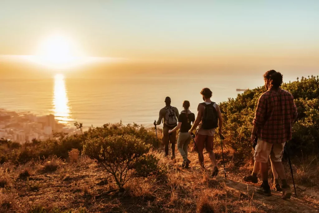 several young adults hiking at sunset