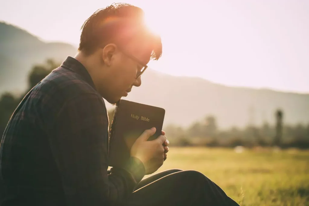 a man with his eyes closed, holding a bible. Two ways we misunderstand sin.
