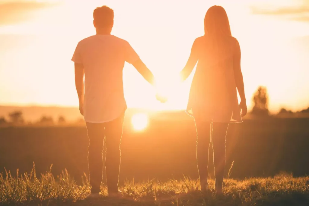 a young christian couple dating, holding hands at sunset